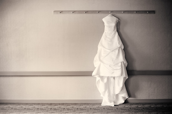 black and white photo of the bride's ball gown dress hanging from a coat rack - photo by Houston based wedding photographer Adam Nyholt 